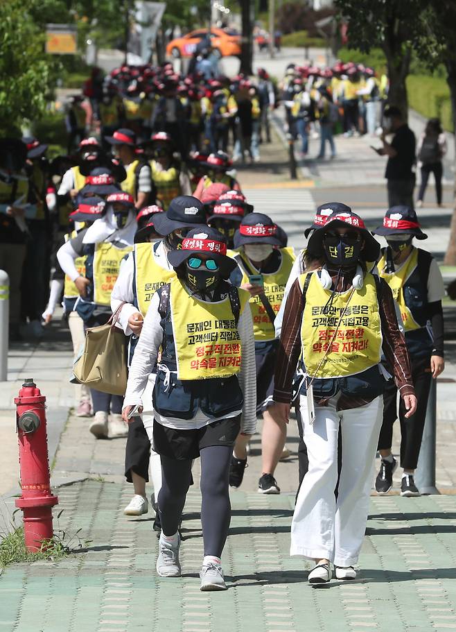 지난 6월 16일 국민건강보험공단 콜센터 노조 조합원들이 공단 직접 고용을 요구하며 서울 여의도에서 청와대를 향해 행진하고 있다. 조합원이 입은 조끼에 "문재인 대통령은 고객센터 직접 고용 정규직 전환 약속 지켜라!"라는 문구가 적혀 있다. /박상훈 기자