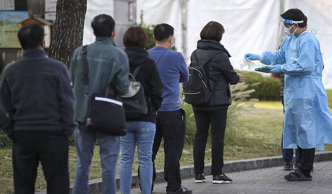 코로나19 국내 신규확진자가 1441명으로 집계된 21일 오전 서울 종로구 흥인지문 인근에 설치된 서울시 찾아가는 선별진료소를 찾은 시민들이 검사를 받기 위해 줄 서 있다. 2021.10.21/뉴시스,