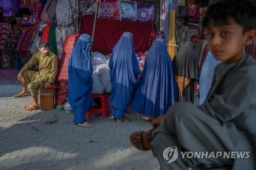 아프간 수도 카불에서 부르카를 입고 이동하는 여성들(가운데) [AFP 연합뉴스 자료사진. 재판매 및 DB 금지]