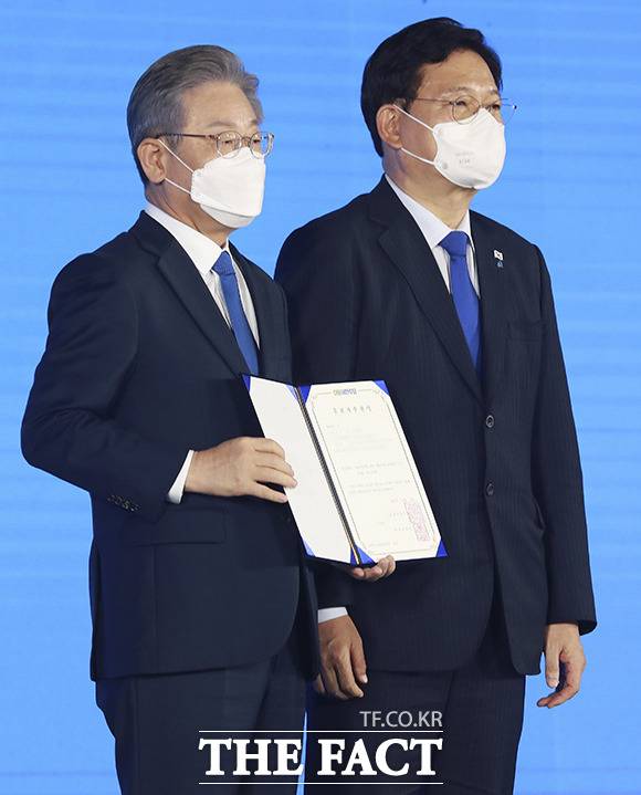 더불어민주당 제20대 대통령 후보에 선출된 이재명 경기도지사가 지난 10일 오후 서울 송파구 올림픽공원 SK올림픽핸드볼경기장에서 열린 서울 합동연설회에서 송영길 대표에게 후보자 추천서를 받고 기념촬영을 하고 있다./ 더팩트 DB