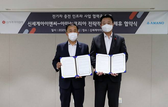 손정현 신세계아이앤씨 대표(오른쪽)와 전명진 아마노코리아 대표(왼쪽)가 21일 서울 중구 신세계아이앤씨 본사에서 전기차 충전 인프라 사업을 위한 업무 협약을 체결했다.