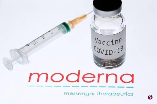모더나사 로고 위에 놓인 코로나19 백신과 주사기의 모습. AFP=연합뉴스