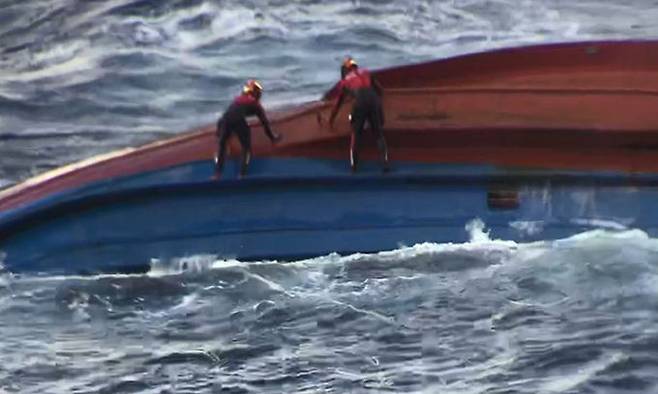 지난 21일 독도 북동쪽 약 168㎞ 공해상에서 전복된 민간 어선 제11일진호(72t급·승선원 9명)에서 해경이 구조자 수색에 나서고 있다. 동해지방해양경찰청 제공