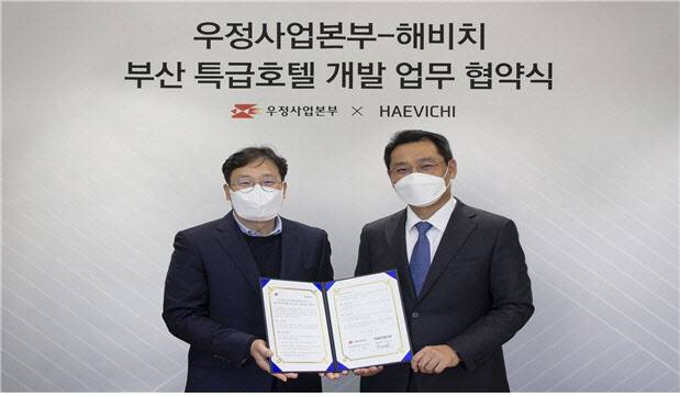 우정사업본부-해비치 부산 특급호텔 개발 업무 협약식이 지난 22일 서울 해비치 본사에서 열려 박인환 우정사업본부 보험사업단장(왼쪽)과 해비치 김민수 대표이사가 기념촬영을 하고 있다. 우정사업본부 제공