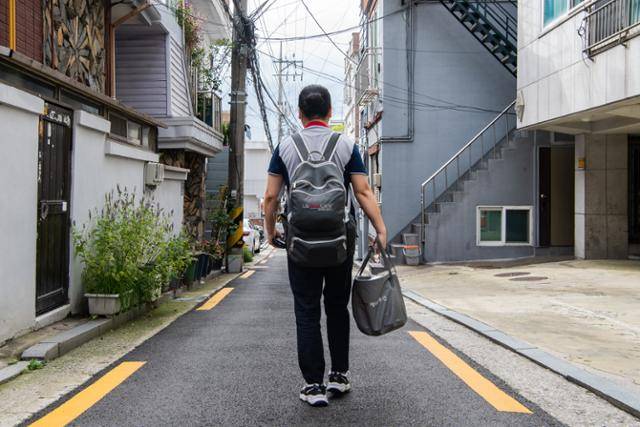 12일, 3년차 방문점검원 LG 케어솔루션 소속 매니저 신현정(49)씨가 고객 자택을 향해 발걸음을 서두르고 있다. 엘리베이터가 없는 오래된 건물의 경우, 계단으로 올라가야 한다. 엘리베이터와 주차장이 완비돼 있는 아파트 단지나 골목 사이사이에 들어선 다세대주택이나 방문 건당 수수료는 동일하다.