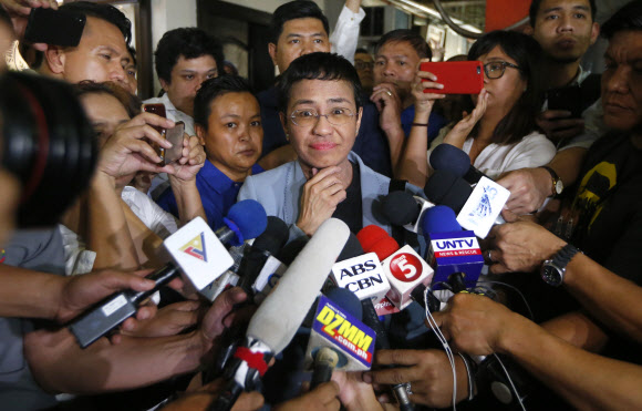 필리핀 언론인 마리아 레사가 2019년 사이버 명예훼손 혐의로 체포됐다가 보석으로 풀려나며 기자들에게 둘러싸여 질문받고 있다. 마닐라 AP 연합뉴스