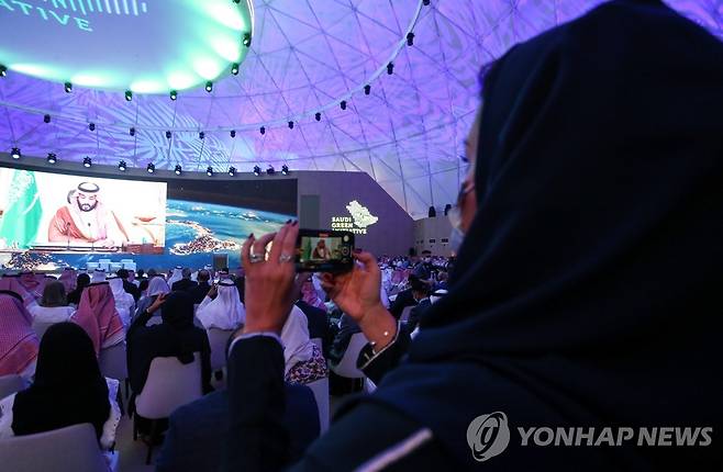 사우디, 2060년까지 탄소중립 선언 (리야드 로이터=연합뉴스) 23일(현지시각) 사우디아라비아 리야드에서 열린 '사우디 녹색 계획' 행사장에서 참석자가 사진 촬영을 하고 있다. 2021.10.23 photo@yna.co.kr