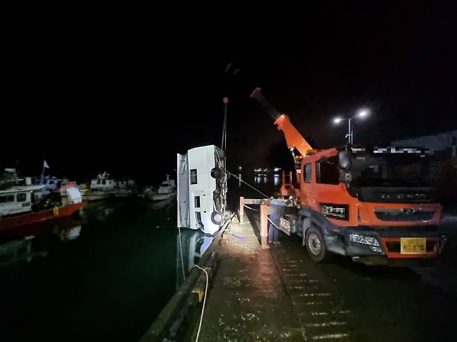 보령 오천항 항구 주변 저지대에 주차된 차량이 침수된 뒤 크레인을 통해 육상으로 인양되고 있다.(보령해경 제공)© 뉴스1