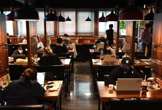 15일 오후 서울의 한 스터디카페에 학생들이 공부를 하고 있다.   정부가 이날 발표한 새 방역지침에 따르면 오는 18일부터 4단계 지역의 식당·카페 영업시간은 오후 10시까지로 계속 제한되지만 독서실·스터디카페·공연장·영화관은 자정까지 운영 시간이 확대된다. 연합뉴스