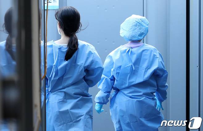 정부가 '위드코로나' 준비에 박차를 가하고 있는 가운데 확진자 폭증으로 인한 의료진의 업무 과다가 우려된다는 목소리가 나오고 있다. 사진은 25일 서울역 임시선별진료소에서 근무중인 의료진. 2021.10.25/뉴스1 © News1 이성철 기자