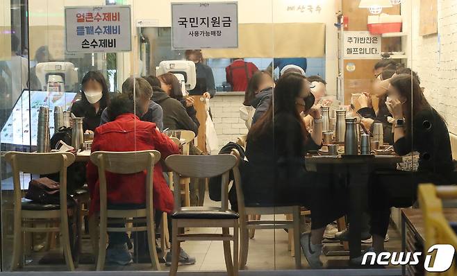 25일 오후 서울 시내의 한 식당에서 시민들이 식사를 하고 있다. 이르면 다음달 1일부터 '단계적 일상회복' 이른바 '위드(with) 코로나'가 시작된다. 2021.10.25/뉴스1 © News1 임세영 기자