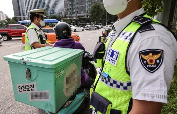교통 경찰관들이 법규를 위반한 오토바이 운전자를 단속하고 있다. 사진=연합뉴스