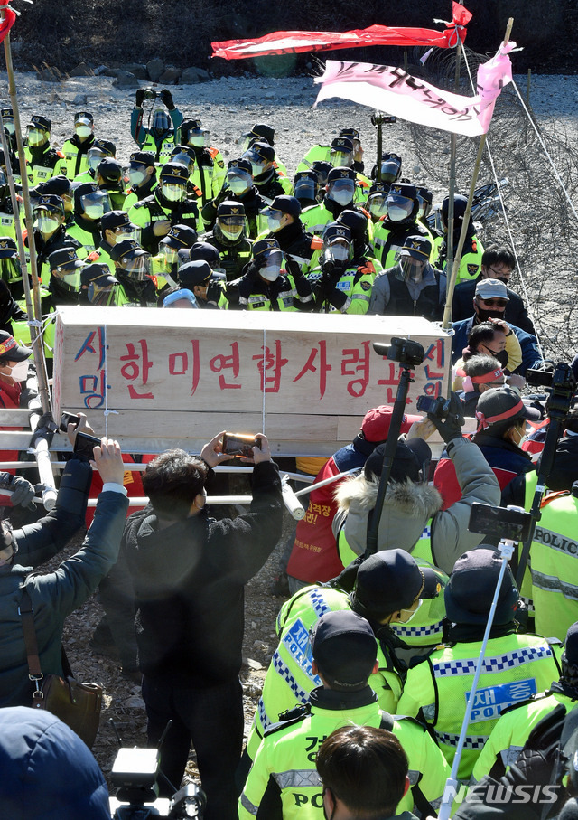 [포항=뉴시스] 이무열 기자 = 4일 경북 포항 남구 장기면 수성사격장 입구에서 미군 아파치 헬기 사격훈련 중단과 수성사격장 폐쇄를 촉구하는 집회가 열린 가운데 집회에 참가한 포항수성사격장반대대책위원회와 장기면 주민들이 상여를 메고 사격장 진입을 시도하고 있다. 2021.02.04. lmy@newsis.com