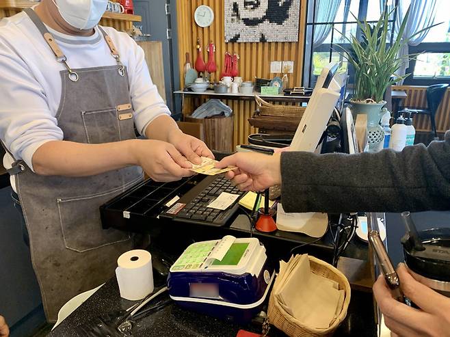 전남 구례군 마산면 한 카페를 찾은 손님이 현금으로 계산하고 있다. 연합뉴스