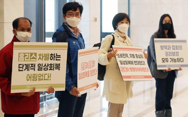 22일 '단계적 일상회복 관련 2차 공개토론회'가 열린 서울 서초구 엘타워에서 코로나19인권대응네트워크 회원들이 차별과 불평등을 양산하는 백신 패스 중단을 촉구하는 시위를 하고 있다. 뉴스1