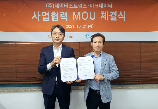 Ko Kwang-yun, CEO of ArkData (left) and Lee Young-sang, CEO of DataStreams (right) hold up a memorandum of understanding document on Monday. (DataStreams)
