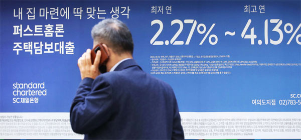 26일 금융위원회가 총부채원리금상환비율(DSR) 규제 일정을 앞당기는 `가계부채 관리 강화 방안`을 발표한 가운데 한 시민이 대출 안내문 앞을 지나가고 있다. [한주형 기자]