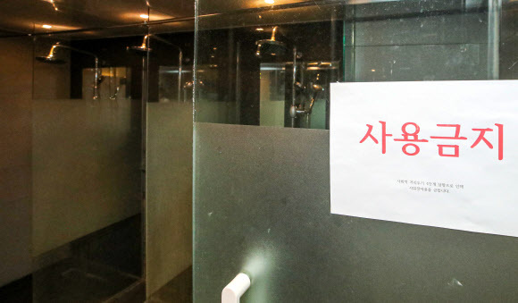 정부가 ‘단계적 일상회복(위드코로나)’ 관련 백신 패스 도입 등 이행 방안을 공개한 25일 오후 서울 강남구 디스이즈피트니스 청담점 샤워실에 사용금지 안내문이 붙어 있다. 뉴시스