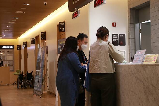 조이씨(왼쪽)와 롬멜씨(가운데)가 지난 5월29일 경기도 포천 소재 한 병원에서 이주민 지원 활동가의 도움을 받아 진료비를 수납하고 있다. 사단법인희망씨 제공