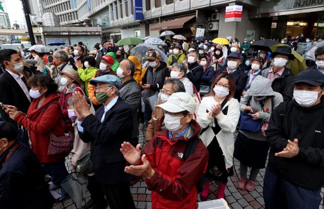 일본 중의원 선거(총선) 공식 선거운동 첫날인 지난 19일 수도 도쿄에서 유권자들이 후보들의 거리 유세를 지켜보며 손뼉을 치고 있다. 오는 31일 투·개표가 실시되는 이번 총선은 집권 자민당이 단독 과반의석을 지킬지에 관심이 쏠려 있다. 도쿄=AFP 지지 연합뉴스