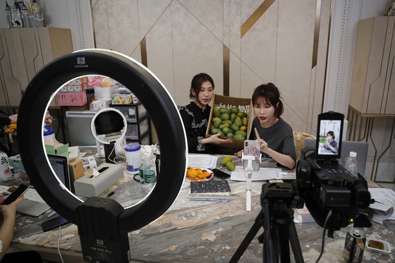 중국의 유명 아나운서 장 모팡(오른쪽)이 자택에서 라이브 스트리밍 방송으로 망고를 판매하고 있다. [AP=연합뉴스]