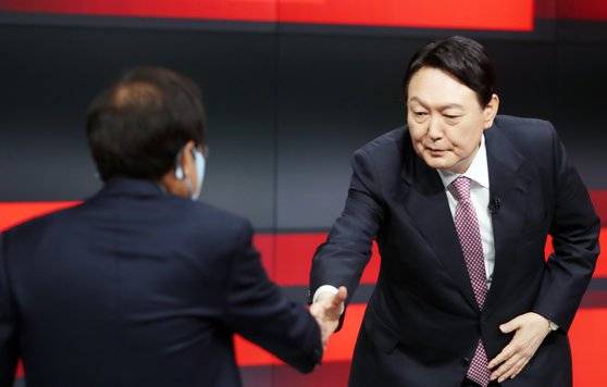 27일 오후 강원 춘천시 동면 G1 강원민방에서 열린 국민의힘 대선 경선 후보 합동토론회에 참석한 홍준표(왼쪽) 후보와 윤석열 후보가 악수를 하고 있다. 연합뉴스