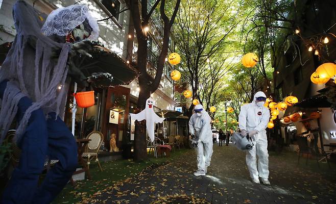 District public health workers are photographed disinfecting a street in Yongin, Gyeonggi Province, on Wednesday. (Yonhap)