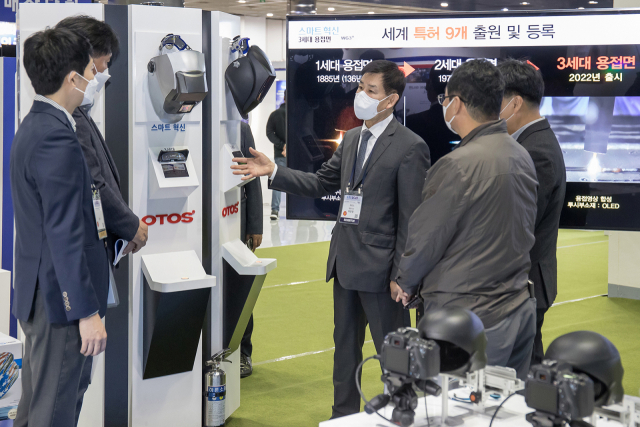 27일 서울 코엑스에서 열린 '2021 스마트비즈엑스포'에 참가한 허문영(가운데) 오토스윙 대표(가운데)가 삼성전자 관계자들과 개발 중인 제품에 대해 협의하고 있다./사진제공=삼성전자