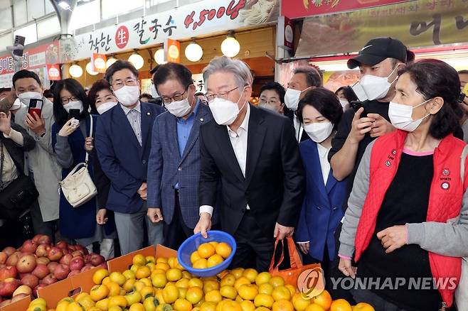 감 구입하는 민주당 이재명 대선 후보 (서울=연합뉴스) 더불어민주당 이재명 대선 후보가 27일 서울 관악구 신원시장을 방문, 과일 상점에서 감을 구입하고 있다. 2021.10.27 [국회사진기자단] toadboy@yna.co.kr