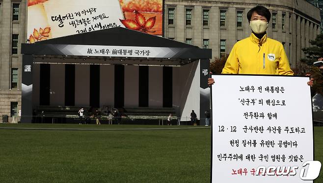 28일 오후 서울 중구 서울광장에 마련된 고(故) 노태우 전 대통령 분향소 앞에서 정의당 관계자가 노태우 전 대통령 국가장에 반대하는 1인 피켓 시위를 하고 있다. 노 전 대통령은 지난 26일 향년 89세를 일기로 별세, 정부는 국가장을 결정했다. 2021.10.28/뉴스1 © News1 이승배 기자