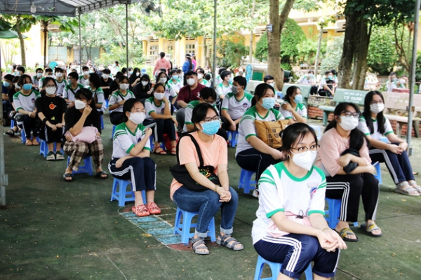 Students wait in line for their turn to receive COVID-19 vaccines. — VNA/VNS Photo Thu Hương