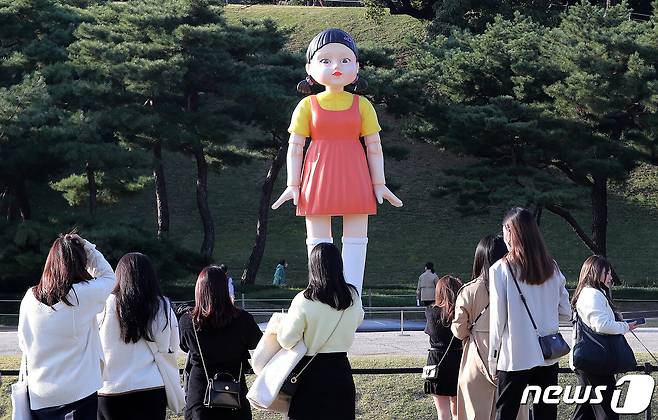 25일 오후 서울 송파구 올림픽공원 야외 88잔디마당에 설치된 넷플릭스 드라마 ‘오징어게임’ 영희 로봇 동상이 시민들 눈길을 끌고 있다. 2021.10.25/뉴스1 © News1 박세연 기자