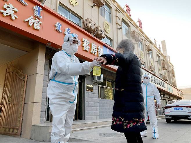 코로나19 확진자가 잇따라 나오고 있는 중국 네이멍구 자치구에서 29일 한 관광객이 코로나19 검사에 앞서 소독을 하고 있다. 어지나기/신화 연합뉴스