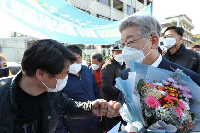 이재명 더불어민주당 대선후보가 29일 경기 성남시 수정구 제1공단 근린공원 조성공사 현장을 둘러 본 뒤 지지자들에게 꽃다발을 받고 인사하고 있다. 뉴스1