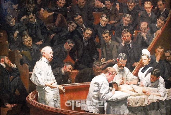 토머스 에이킨스의 ‘애그뉴 박사의 클리닉’(1889). 19세기 미국에서 행해졌을 거라 보이는 수술풍경을 묘사했다. 인물뿐만 아니라 흰 가운을 입은 의사, 마취와 수술집도, 맥막 체크 등 과정까지 세밀하다. 사실주의적 작품이 나온 배경에는 미술공부 외에도 의과대에서 해부학을 공부했던 화가의 견고한 지식이 바탕이 됐다. 캔버스에 유채, 214×300㎝, 미국 펜실베이니아대 소장.