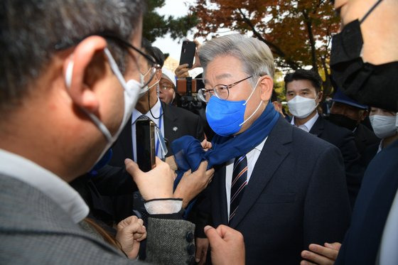 이재명 더불어민주당 대선 후보가 2일 오후 서울 송파구 올림픽공원 체조경기장에서 열린 제20대 대통령선거 선거대책위원회 출범식을 마친 후 한 지지자에게 푸른 머플러를 선물받고 있다. 뉴스1