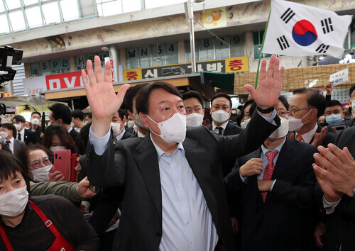 Former Prosecutor General Yoon Seok-youl, a candidate in the PPP presidential primary, greets supporters while paying a visit to Cheonan Central Market in the city of Cheonan, South Chungcheong Province, on Tuesday. (Yonhap News)