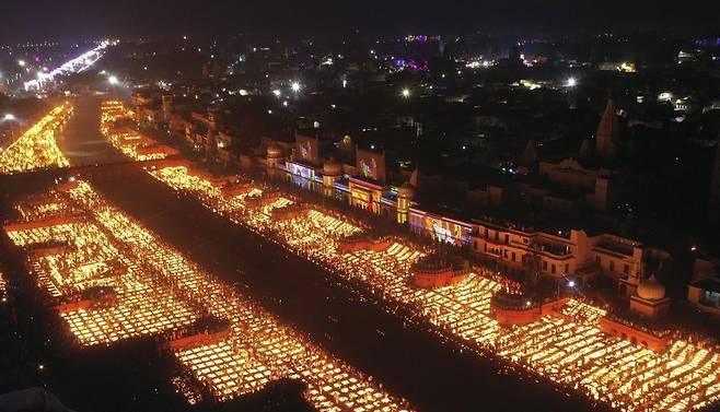 인도 현지시간으로 3일 아요디아의 사류강 유역에서 사람들이 등불을 켜고 있다. 이날 힌두교 최대 축제인 디왈리의 일환으로 90만 개가 넘는 등불이 켜졌다. AP 연합뉴스