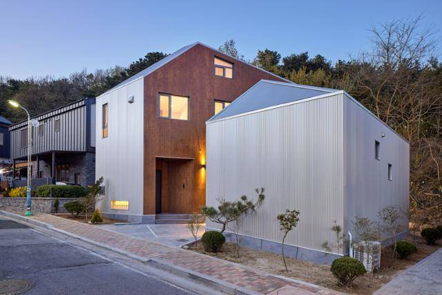 경기 용인 단독주택 '내맘이당'은 사각형, (지붕을 포함하면) 사각뿔 모양 집을 비스듬히 쪼갠 형태다. 지붕부터 외벽까지는 밝은 골강판으로, 두 건물이 마주 보고 있는 면은 짙은 탄화목으로 마감했다. 집 이름 '내맘이당'은 건축주가 건축가와 회의를 할 때 가장 많이 했던 말이 '내 마음대로'라는데서 따왔다. 노경 건축사진작가 제공