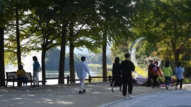 지난달 24일 경기 구리 수택동 장자호수생태공원 내 호수 옆 흙길을 시민들이 걷고 있다. 배우한 기자