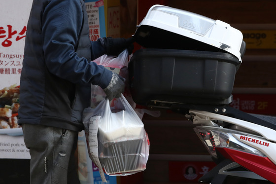 A delivery rider delivers food on a motorcycle. [YONHAP]