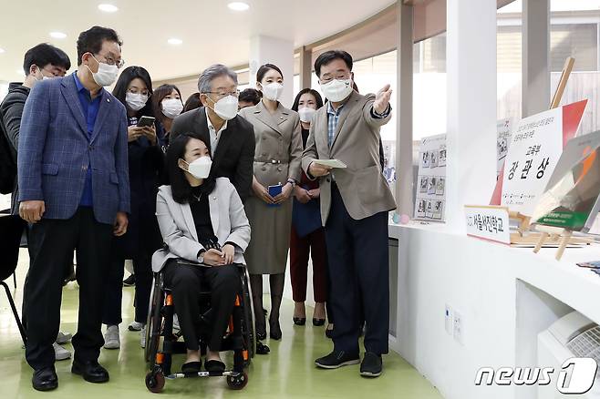 이재명 더불어민주당 대선 후보가 7일 서울 강서구 공립 지적장애 특수학교인 서진학교를 방문해 최혜영 의원의 휠체어를 밀어주며 홍용희 교장의 안내를 받고 있다. 2021.11.7/뉴스1 © News1 구윤성 기자