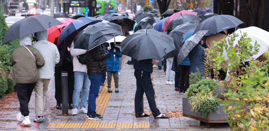 8일 오전 서울 송파구 보건소 코로나19 선별검사소에서 시민들이 검사를 받기 위해 우산을 쓴 채 차례를 기다리고 있다. 연합뉴스