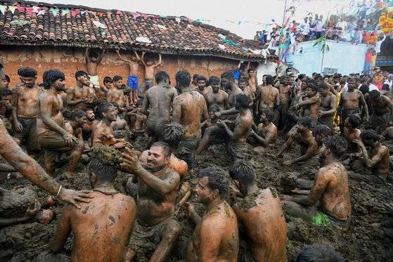 지난 6일 인도 카르나타카주 벵갈루루 인근 마을에서 열린 '고레 하바' 축제. 소똥을 눈처럼 뭉쳐 던지며 싸움을 하고, 소똥밭에서 구르는 행사다. 대회엔 남성들만 참가하는데, 노마스크에 알몸 참가자가 대부분이라 코로나19가 재확산 할 수 있다는 우려가 나온다. AFP=연합뉴스