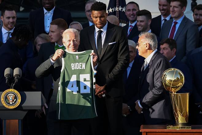 미국의 조 바이든 대통령이 NBA 우승팀 밀워키 벅스 선수들로부터 자신의 이름이 쓰여진 저지를 들어보이고 있다.[USA투데이]