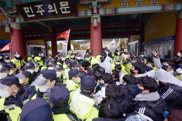 ‘경찰 펜스가 왜 있냐’ - 전두환 미화’ 발언과 ‘개 사과’로 논란을 일으킨 윤석열 국민의힘 대선후보의 광주 방문을 앞둔 10일 오전 광주 북구 운정동 국립5?18민주묘지에서 오월어머니집, 광주전남대학생진보연합 관계자들이 경찰펜스를 부시며 항의하고 있다. 2021.11.10/뉴스1