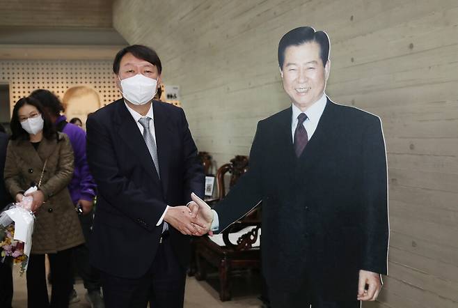 국민의힘 윤석열 대선 후보가 11일 오전 전남 목포시 김대중 노벨평화상기념관를 방문, 김 전 대통령의 1대1 크기 사진과 악수하는 포즈를 취하고 있다. 연합뉴스