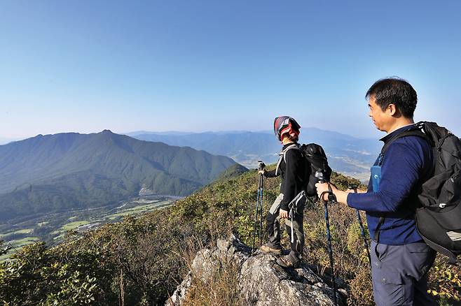 두무산 정상 북쪽의 바위에 오르면 건너편 비계산이 손을 뻗으면 닿을 듯하다. 그 뒤로 수도산, 단지봉, 가야산, 남산제일봉 등이 펼쳐진다.