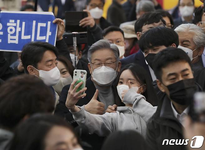 전국 민생탐방 투어에 나선 이재명 더불어민주당 대선 후보가 12일 오후 울산 중구 울산중앙전통시장을 찾아 시민들과 스마트폰 셀카를 찍고 있다. 이 후보는 이날 부산·울산·경남을 시작으로 약 8주간 버스를 타고 전국 곳곳의 목소리를 경청하는 매타버스(매주 타는 민생버스) 프로젝트에 돌입했다. 2021.11.12/뉴스1 © News1 윤일지 기자