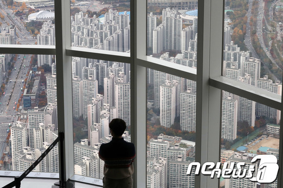 서울 송파구 롯데월드 서울스카이 전망대를 찾은 관람객이 아파트단지가 밀집한 서울시내를 바라보고 있는 모습.  (서울=뉴스1) 박세연 기자© 뉴스1